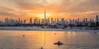 Image of Dubai with beautiful sunset and mix od land and sea with boats